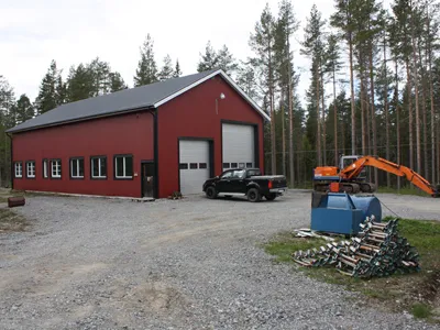 Team Skogs röda verkstadsbyggnad med grusplan